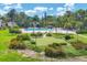 Aerial view of a community pool and putting green surrounded by tropical landscaping and lush greenery at 4310 Falmouth Dr # 102, Longboat Key, FL 34228