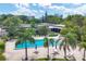 Aerial view of sparkling community pool surrounded by palm trees, lounge chairs, and lush greenery at 4310 Falmouth Dr # 102, Longboat Key, FL 34228