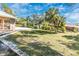 Expansive backyard with lush greenery and mature palm trees, perfect for outdoor activities at 4540 Maverick St, North Port, FL 34288