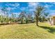 Expansive backyard with lush greenery and mature trees, offering plenty of space for outdoor enjoyment and activities at 4540 Maverick St, North Port, FL 34288