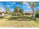 Large backyard with a mix of palm trees and lush vegetation, with a screened pool and outdoor living space at 4540 Maverick St, North Port, FL 34288