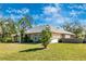 Beautiful home exterior with a well-manicured lawn and mature trees at 4540 Maverick St, North Port, FL 34288