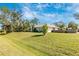 Well-manicured front yard leading to an attractive home, complemented by mature trees and lush landscaping at 4540 Maverick St, North Port, FL 34288