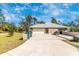 A spacious garage with ample driveway space on a well-maintained property with lush green lawn at 4540 Maverick St, North Port, FL 34288