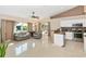 A spacious living room featuring tile flooring, neutral paint, and an adjacent kitchen with modern appliances at 4540 Maverick St, North Port, FL 34288