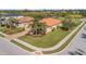 Aerial view of home and community featuring a tile roof, well-manicured lawns, and a beautiful pond at 4802 68Th Street E Cir, Bradenton, FL 34203