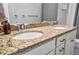 Close-up of a bathroom vanity featuring granite countertops, dual sinks with chrome faucets, and white cabinetry at 4802 68Th Street E Cir, Bradenton, FL 34203