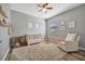 Charming Bedroom with wooden crib, ceiling fan, cozy chair, and neutral tones creating a peaceful atmosphere at 4802 68Th Street E Cir, Bradenton, FL 34203