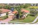 Well-manicured front yard with mature landscaping, palm trees, and a brick driveway leading to a two-car garage at 4802 68Th Street E Cir, Bradenton, FL 34203