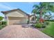 Close up exterior of a well-maintained home with mature landscaping, a brick driveway, and a 2-car garage at 4802 68Th Street E Cir, Bradenton, FL 34203