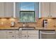 Kitchen features a stainless steel sink, granite countertops, white cabinetry, and a view from the window at 4802 68Th Street E Cir, Bradenton, FL 34203