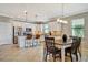 View of kitchen with white cabinets, stainless steel appliances and an eat-in island with dining table nearby at 4802 68Th Street E Cir, Bradenton, FL 34203