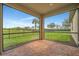 Corner view of screened-in patio shows the brick flooring, clear blue sky, and green lawn at 4802 68Th Street E Cir, Bradenton, FL 34203