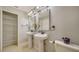 Bathroom featuring dual sinks, updated lighting, with access to a closet at 4937 Thames Ln, Sarasota, FL 34238