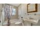 This bathroom features a shower and tub combination, tile surround, decorative mirror and a vanity sink at 4937 Thames Ln, Sarasota, FL 34238