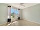 This is a basic bedroom with tile flooring, a ceiling fan, and a window with decorative black-and-white curtains at 4937 Thames Ln, Sarasota, FL 34238