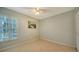 This is a simple bedroom with a large window with shutters, and tile flooring at 4937 Thames Ln, Sarasota, FL 34238