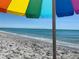 Relaxing beach view under a colorful umbrella with calm turquoise waters and a sandy shoreline at 5031 N Beach Rd # 222, Englewood, FL 34223