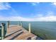 Long wooden dock extending into calm waters under a clear blue, partly cloudy sky at 5031 N Beach Rd # 222, Englewood, FL 34223