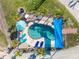 An aerial view of the kidney-shaped pool surrounded by palm trees and a brick-paved lounging area at 5031 N Beach Rd # 222, Englewood, FL 34223