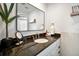 Modern bathroom featuring black granite countertops, white cabinets, and a large mirror at 507 67Th W Ave, Bradenton, FL 34207