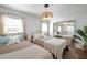 Bright bedroom featuring two beds, wood floors, ample natural light, and a contemporary light fixture at 507 67Th W Ave, Bradenton, FL 34207