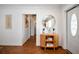 Stylish home entryway featuring elegant wood flooring, a round mirror, and a chic accent table at 507 67Th W Ave, Bradenton, FL 34207