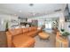 Open-concept living room featuring a leather sofa, modern decor, and seamless access to the kitchen at 507 67Th W Ave, Bradenton, FL 34207