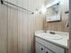 Bathroom featuring white vanity with a countertop sink, a mirror, and paneled walls at 511 50Th Avenue W Dr, Bradenton, FL 34207