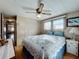 Bedroom featuring paneled walls, windows providing natural light, a ceiling fan, and laminate flooring at 511 50Th Avenue W Dr, Bradenton, FL 34207