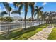 Waterfront backyard with palm trees, well-maintained grass, and a private dock at 537 Fore Dr, Bradenton, FL 34208