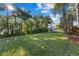 Lush backyard featuring a well-manicured lawn and beautiful tropical landscaping with mature palm trees at 537 Fore Dr, Bradenton, FL 34208