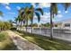 Backyard view of waterfront property featuring lush palms, a seawall and paver pathway at 537 Fore Dr, Bradenton, FL 34208