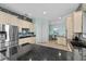 Contemporary kitchen with stainless steel appliances, a kitchen island with bar stools, and adjacent dining area at 537 Fore Dr, Bradenton, FL 34208