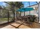 Screened-in patio with dining table and a blue umbrella, perfect for entertaining at 537 Fore Dr, Bradenton, FL 34208