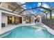 Beautiful pool and spa area with covered patio, plenty of seating and tropical foliage at 537 Fore Dr, Bradenton, FL 34208