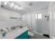 Well-lit bathroom with a large mirror, bright white tile, and turquoise vanity at 5807 De Palmas Ave, Holmes Beach, FL 34217