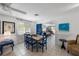 Cozy dining room with a modern table, stylish blue chairs, and ample natural light with a living area in background at 5807 De Palmas Ave, Holmes Beach, FL 34217