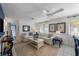 Bright living room featuring white sofas, neutral rug, and a ceiling fan, seamlessly connected to the dining area at 5807 De Palmas Ave, Holmes Beach, FL 34217