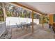 Outdoor patio with dining table surrounded by tropical landscaping and a white fence at 5807 De Palmas Ave, Holmes Beach, FL 34217