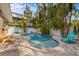 Private backyard pool featuring a custom shape, brick patio, and tropical foliage at 5807 De Palmas Ave, Holmes Beach, FL 34217