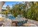 Backyard pool surrounded by tropical foliage, various seating, and brick pavers at 5807 De Palmas Ave, Holmes Beach, FL 34217