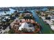 Aerial view showcases the property's waterfront access and lush landscaping in a coastal setting at 607 Baronet Ln, Holmes Beach, FL 34217