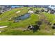 Panoramic aerial of a beautifully landscaped golf course, complemented by a serene pond and mature palm trees at 607 Baronet Ln, Holmes Beach, FL 34217