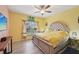 Bright bedroom featuring a tufted headboard, ceiling fan, and a window letting in natural light at 6330 Green Oak Cir # D, Bradenton, FL 34203