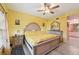 Bright bedroom showcasing a tufted headboard, ceiling fan, and an ensuite bathroom at 6330 Green Oak Cir # D, Bradenton, FL 34203