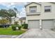 Two-story townhome featuring a two-car garage, neutral stucco exterior, and manicured lawn with shrubbery at 6330 Green Oak Cir # D, Bradenton, FL 34203