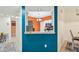 View of modern kitchen area through a serving hatch, featuring white cabinets and updated appliances at 6330 Green Oak Cir # D, Bradenton, FL 34203