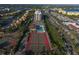 Aerial view showcasing tennis courts, a pool, and surrounding buildings at 6415 Midnight Pass Rd # 508, Sarasota, FL 34242