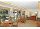 Inviting dining area with wicker chairs, glass top tables, large windows, and view of the pool and tropical foliage at 6415 Midnight Pass Rd # 508, Sarasota, FL 34242